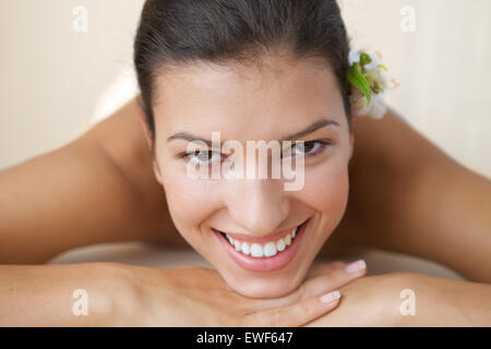 Nahaufnahme der fröhliche junge Frau, die entspannend auf Massagetisch Stockfoto