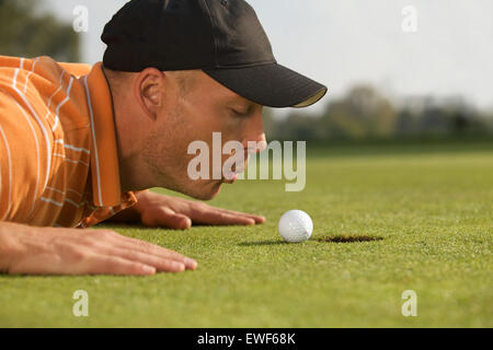 Nahaufnahme des Menschen weht auf Golfball Stockfoto