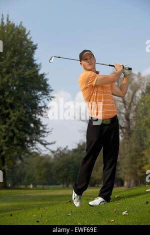 Junger Mann schwingenden Golf club Stockfoto