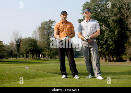 Porträt der jungen Männer stehen mit Golf-Sticks auf Golfplatz Stockfoto