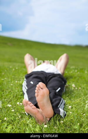 Junge Mann liegt auf dem Rasen im park Stockfoto
