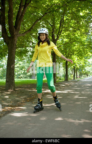 Yong-Frau-Reiten-Rollschuh Stockfoto