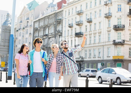 Glücklicher Mann zeigen etwas an Freunde auf Stadt Straße Stockfoto