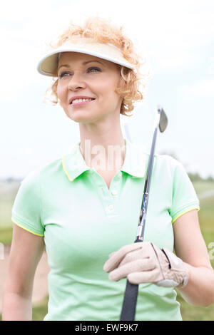 Nachdenkliche Frau mittleren Alters wegsehen gedrückter Golf club Stockfoto