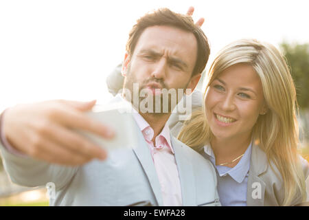 Spielerische Geschäft paar nehmen Selfie im Freien an sonnigen Tag Stockfoto