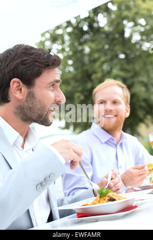 Geschäftsleute, die mit Essen im Restaurant im freien Stockfoto