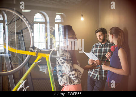 Lässige Geschäftsleute diskutieren Papierkram im Büro Stockfoto