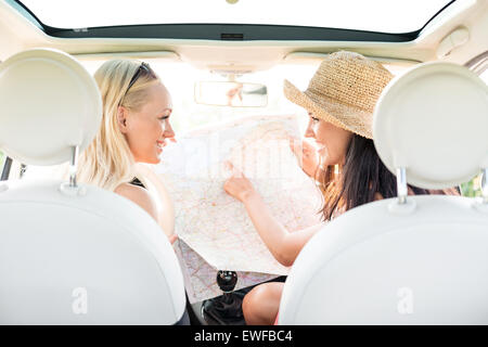 Rückansicht des glücklich Freundinnen lesen Karte im Auto Stockfoto