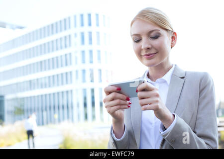Geschäftsfrau Textnachrichten durch Smartphone im freien Stockfoto
