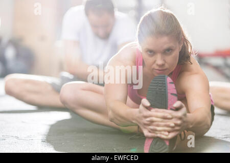 Porträt der selbstbewusste Frau tun stretching-Übung im Crossfit gym Stockfoto