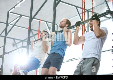 Niedrigen Winkel Ansicht der engagierte Männer tun Klimmzüge in Crossfit gym Stockfoto