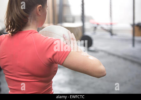 Rückansicht des Frau mit Medizinball in Crossfit gym Stockfoto