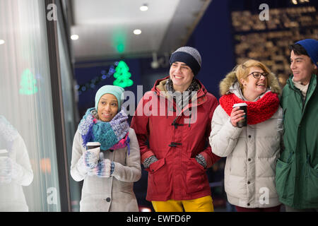 Glücklich multiethnischen Freunde im Winter tragen zu Fuß in die Stadt während der Dämmerung Stockfoto