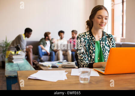 Kreative Geschäftsfrau arbeiten am Laptop mit Papierkram im Büro Stockfoto