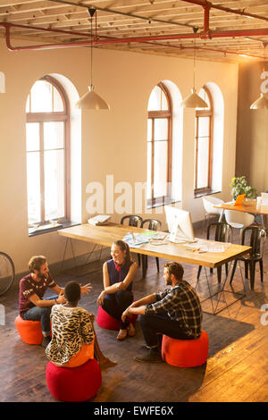 Kreative Geschäftsleute sprechen im Kreis im Büro Stockfoto