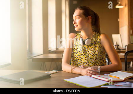 Nachdenklich lässig Geschäftsfrau mit Kopfhörern wegschauen im Büro Stockfoto