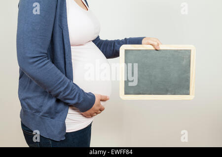 Schwangere Frau mit einer Tafel Stockfoto