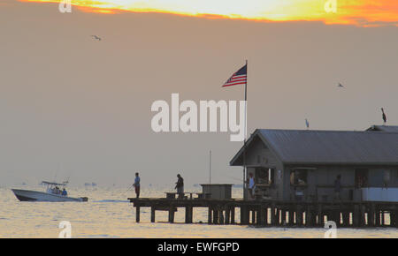 Anna Maria Island, Florida, USA. Juni 2015. Die anfängliche Sonnenauffahrt war heute Morgen am City Pier von Wolken am Horizont blockiert. Ein ruhiger, warmer Start bei 80 F mit der Möglichkeit zu saisonalen Stürmen später Stockfoto