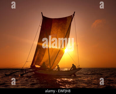 Fischer auf einem Katamaran bei Sonnenuntergang. Stockfoto