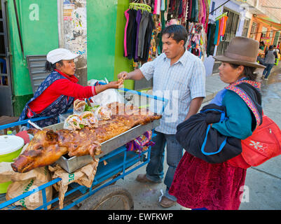 Eine Quechua-Indianerin Verkauf gebratenes Spanferkel und Sandwiches auf der Straße, Huaraz, Nord-Peru, Peru Stockfoto