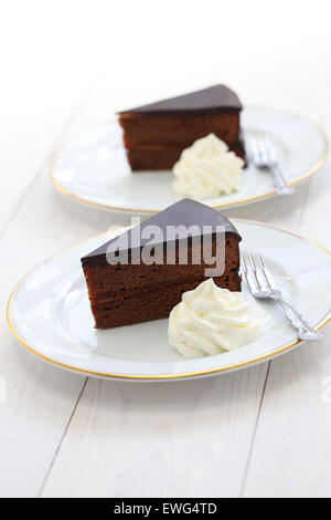 hausgemachte Sachertorte, österreichische Schokoladenkuchen isoliert auf weißem Hintergrund aus Holz Stockfoto