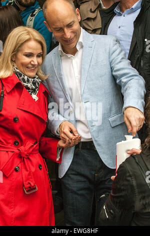 Danisg PM, Helle Thorning-Schmidt (Soc.dem) und ihr Ehemann, Stephen Kinnock hinterlässt der PM lokale Wahllokal am Kildevaeldsskolen auf Oesterbro in Copeenhagen wo sie gegossen ihre Stimme. Auf dem Foto gibt Stephen Kinnock eine Münze zu einem Charity-Kollektion Stockfoto