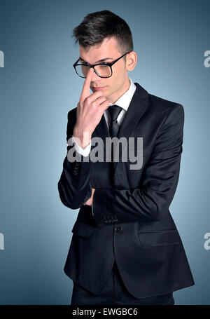 Business-Mann denken auf blauem Hintergrund Stockfoto
