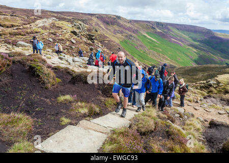 Eine große walking Gruppe. Wanderer Wandern auf einen Stein weg oben auf Grindsbrook Clough, Kinder Scout, Derbyshire, Peak District, England, Großbritannien Stockfoto