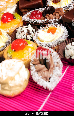 Viele verschiedene Kuchen auf rosa Tisch Stockfoto