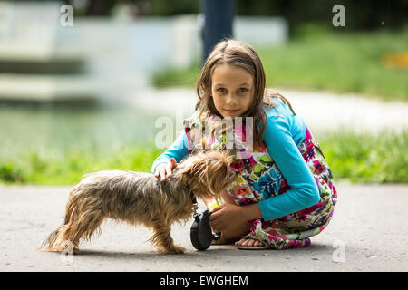 Süßes kleines Mädchen auf der Straße mit einem kleinen Hund. Stockfoto