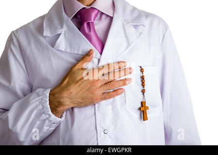 Büste eines Mannes tragen medizinische Weißkittel, blasse Fuchsia Hemd und glänzend Fuchsia Krawatte und Rosenkranz Holzperlen in Tasche am Herzen halten Stockfoto