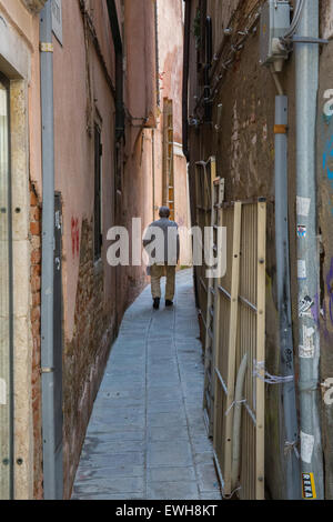 Älterer Herr, der hinunter einer schmale Gasse in Venedig Italien Stockfoto