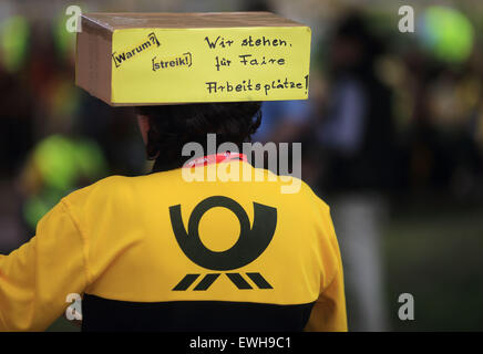 Magdeburg, Deutschland. 26. Juni 2015. Ein Mitarbeiter der Deutschen Post Unternehmen Deutsche Post AG trägt eine Box auf ihrem Hut, die "Wir Stehen Fuer Faire Arbeitsplaetze" liest (lit.) Wir unterstützen faire Arbeitsplätze) während einer Kundgebung der Gewerkschaft Verdi in Magdeburg, Deutschland, 26. Juni 2015. Rund 280 Mitarbeiter in den Einzelhandel und die Postdienste haben versammelt, um ihren Forderungen nach höheren Löhnen zu unterstützen. Foto: JENS WOLF/Dpa/Alamy Live News Stockfoto