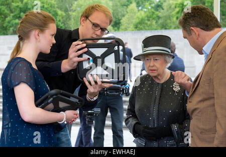 Celle, Deutschland. 26. Juni 2015. Indien Stutzke und Nils Scholl, Schüler an der Kaiserin-Auguste-Viktoria-Gymnasium und Entwickler Paul Verschure (R) zeigen die britische Königin Elizabeth II auf einem Tablet wie Bergen-Belsen als Konzentrationslager während der Queen-Besuch auf dem Gelände des ehemaligen KZ der Bergen-Belsen, in Bergen in der Nähe von Celle, Deutschland, 26. Juni 2015 aussah. Königin Elizabeth II und Herzog von Edinburgh sind auf ihre fünfte Staatsbesuchs in Deutschland vom 23. bis 26. Juni. : Bildnachweis JULIAN STRATENSCHULTE/Dpa: Dpa picture-Alliance/Alamy Live News Stockfoto