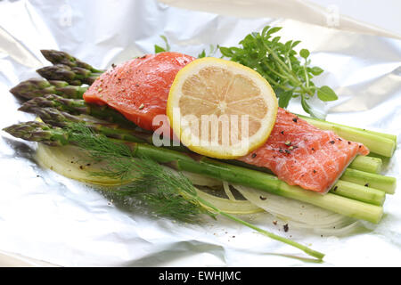 frischer Lachs mit Spargel in Folie Papier, bereit für das Kochen Stockfoto