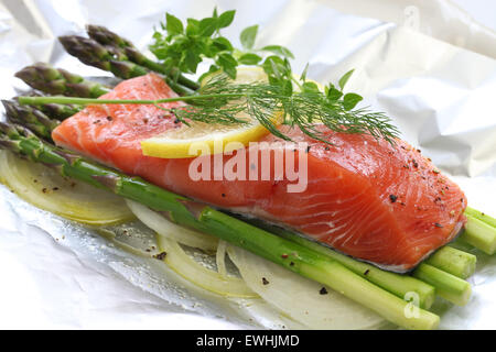 frischer Lachs mit Spargel in Folie Papier, bereit für das Kochen Stockfoto