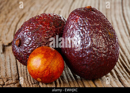 Nahaufnahme von zwei Reife Avocados und Avocado Stein auf einem alten rustikalen Holzbrett Stockfoto