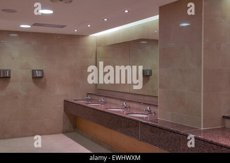 Waschbecken in einer öffentlichen Toilette mit Spiegel und Hand Trockner Stockfoto