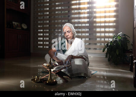 Alte indische Frau Ramayana zu Hause lesen Stockfoto