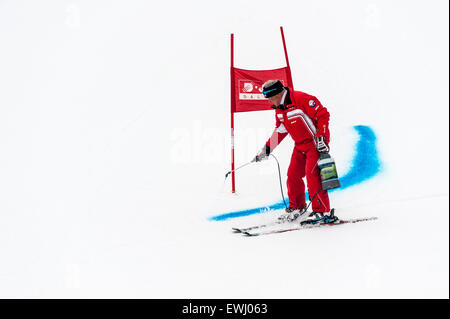 Ein Kurs Marschall Markierung der Ski-Piste mit blauen Farbstoff vor einem Riesenslalom-Rennen. Ein Rennen Tor im Hintergrund. Stockfoto