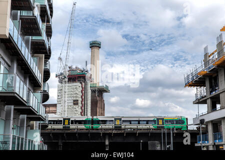 Zug auf einer Eisenbahnbrücke vor Bauarbeiten am Battersea Power Station hinter in Südlondon. Stockfoto