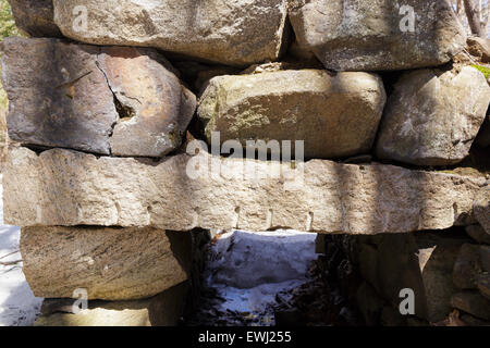 Die Überreste eines verlassenen Granit-Stiftung aus der 19.-20. Jahrhundert Bergsiedlung in den Wald der Hügelkette St Stockfoto