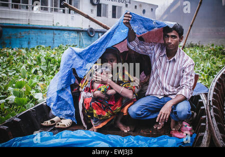 Dhaka, Bangladesch. 26. Juni 2015. Menschen, die sich vor Regen mit Polyethylen-Platten in einem Boot auf dem Fluss Buriganga zu schützen. Monsun-Regen beginnt in Bangladesch von Juni bis Oktober. © Belal Hossain Rana/Pacific Press/Alamy Live-Nachrichten Stockfoto