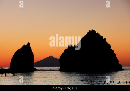 Avlonas Bucht felsigen Inseln (Inseln) Silhouetten in leichten warmen Sonnenuntergang getaucht. Myrina, Lemnos oder Limnos Insel, Griechenland. Stockfoto