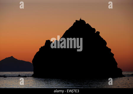 Avlonas Bucht felsigen Inseln (Inseln) Silhouetten in leichten warmen Sonnenuntergang getaucht. Myrina, Lemnos oder Limnos Insel, Griechenland. Stockfoto