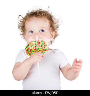 Niedliche Baby mit großen blauen Augen mit einem bunten Bonbons, isoliert auf weiss Stockfoto