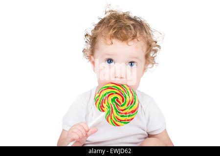 Niedliche Baby mit großen blauen Augen mit einem bunten Bonbons, isoliert auf weiss Stockfoto