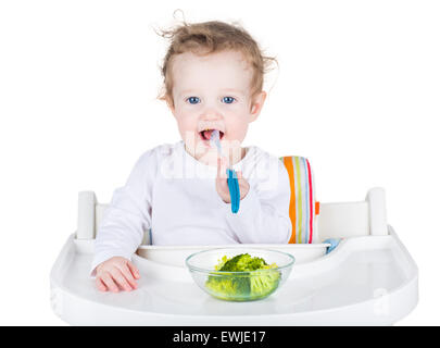 Süßes Lächeln auf den Lippen Baby Essen Brokkoli, isoliert auf weiss Stockfoto