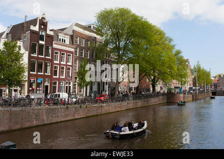 Panoramablick auf der Brücke über den Fluss Amstel mit Personen und Fahrräder und blauer Himmel im Hintergrund in Amsterdam. Stockfoto