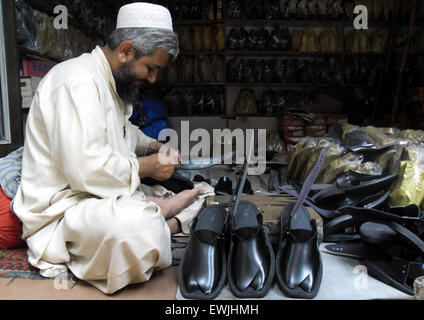 Peshawar. 27. Juni 2015. Ein pakistanischer Mann macht traditionelle Peshawari Chappal bei einem Workshop in Nordwest-Pakistan Peshawar, 27. Juni 2015. Peshawari Chappal ist ein traditionelles Schuhwerk von Pakistan, getragen vor allem von Paschtunen Khyber Pakhtunkhwa Region von Pakistan. © Ahmad Sidique/Xinhua/Alamy Live-Nachrichten Stockfoto